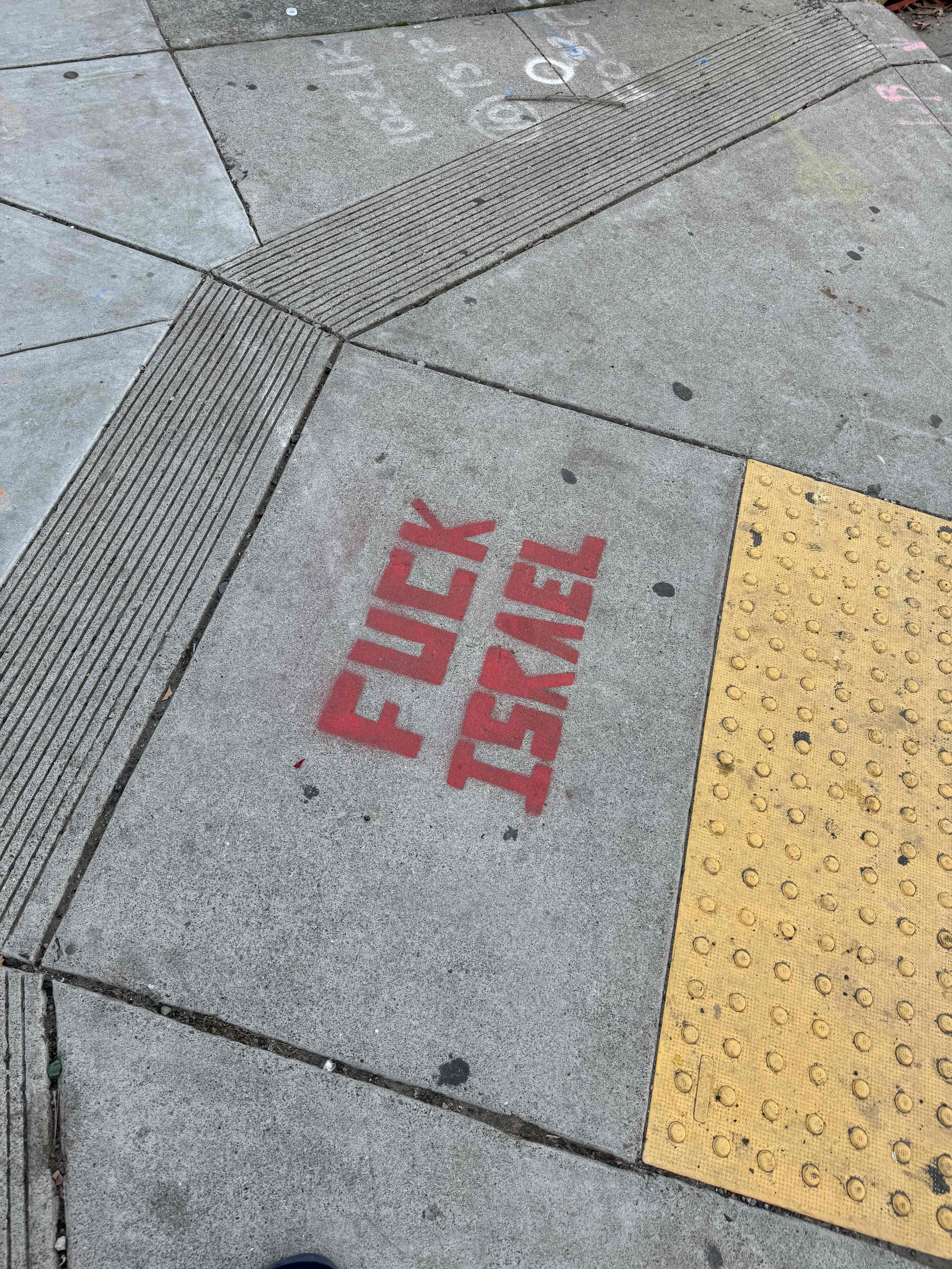 "Fuck Israel" stencil spray painted on sidewalk